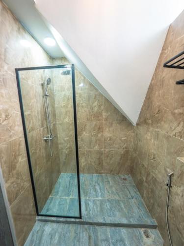 a shower with a glass door in a bathroom at Whales Lodge in Maamigili