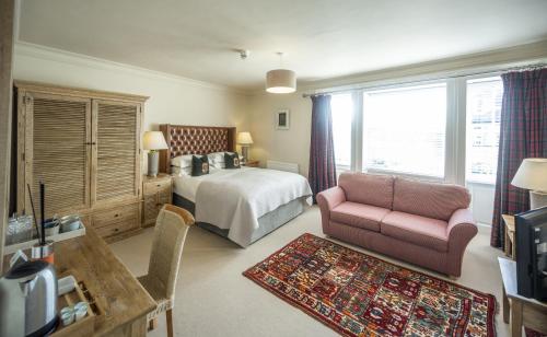 a bedroom with a bed and a couch and a chair at Black Bull in Lauder