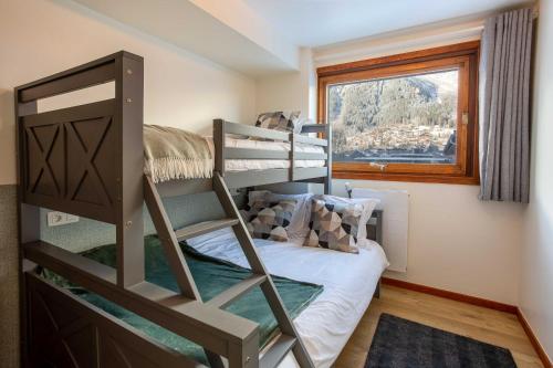 une chambre avec un lit superposé et une fenêtre dans l'établissement Les Trois Balcons Apartment - Chamonix All Year, à Chamonix-Mont-Blanc