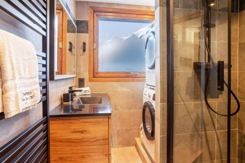 une salle de bain avec un lavabo et une douche dans l'établissement Les Trois Balcons Apartment - Chamonix All Year, à Chamonix-Mont-Blanc