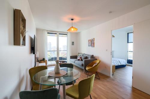 un salon avec une table en verre et des chaises dans l'établissement Dolce Sarah, à Asnières-sur-Seine