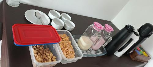 a table with three plastic containers of food on it at Hospedaje Familia Puma in Valeria del Mar
