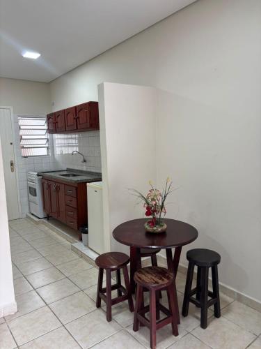 a kitchen with a table and stools in a room at Pousada Albamar Guarujá in Guarujá
