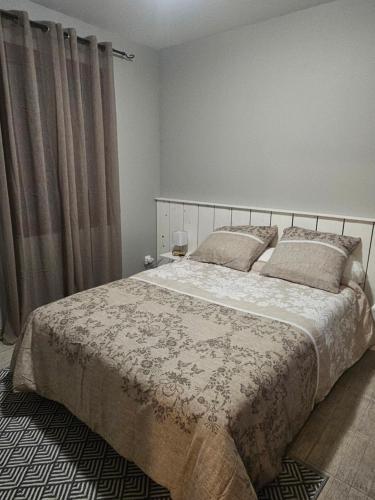 - une chambre avec un grand lit et des rideaux dans l'établissement Gite du Pin de Pardaillan, à Pardaillan