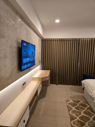 a room with a tv on a wall with a bed at MoonBasa Boutique Hotel and Spa Infopark , Kakkanad in Cochin