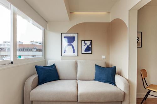 a living room with a couch with blue pillows at Vibe Apartments by Olala Homes in Hospitalet de Llobregat