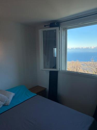 une chambre avec une fenêtre avec vue sur l'océan dans l'établissement Appartement T3 avec vue mer à 15 minutes de Moriani-Plage, à San-Giovanni-di-Moriani
