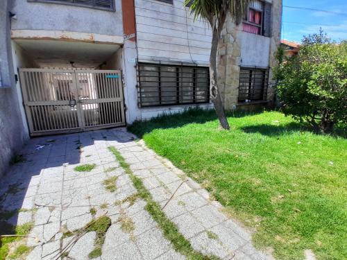 Museo Mar في مار ديل بلاتا: مبنى فيه بوابة وشجر في العشب