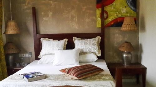 a bedroom with a bed with white sheets and pillows at Accra Royal Castle Apartments & Suites in Kwabenya