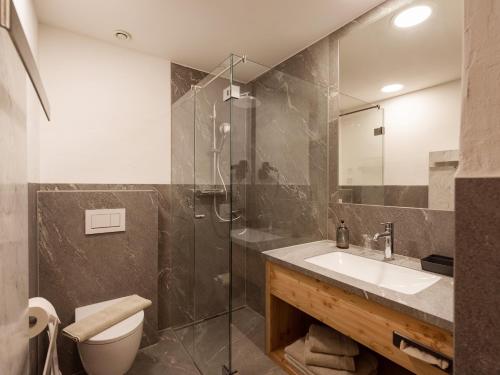 a bathroom with a toilet and a sink and a shower at Hotel Ritterhof Ellmau in Ellmau