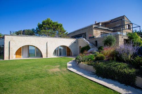 Una gran casa de ladrillo con un patio verde. en 8-bedroom luxury villa with pool, en Gordes