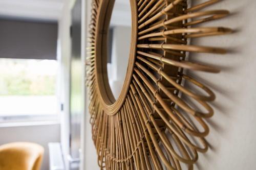 a mirror hanging on a wall next to a chair at Kruisbek I Chic Huisje met Riante Tuin in Zwiggelte