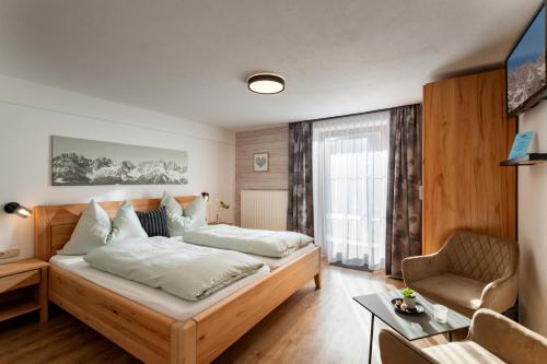 a bedroom with a bed and a desk and a chair at Haus Kaufmann in Ellmau