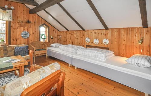 a bedroom with two beds in a room with wooden walls at 4 Bedroom Nice Home In Tived in Tived