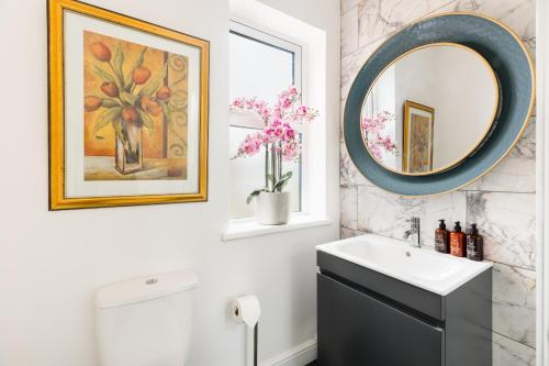 a bathroom with a sink and a mirror at Queens Head Boutique Hotel Apartments in Gloucestershire
