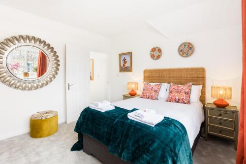 a bedroom with a large bed and a mirror at Queens Head Boutique Hotel Apartments in Gloucestershire