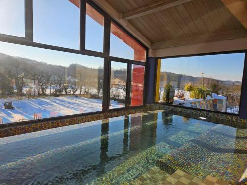 a swimming pool in a house with a large window at Hotel Casa Art in Oreshak