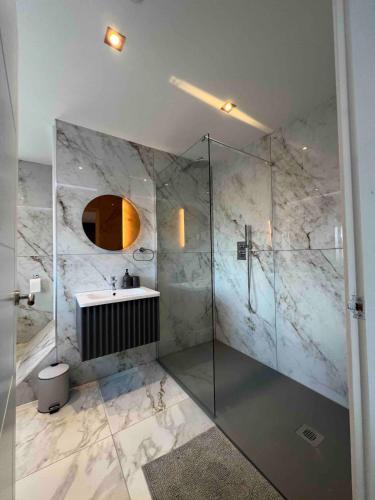 a bathroom with a glass shower and a sink at The Place with king beds, Ensuite Bathrooms, Close to Airport and Free Parking in Wythenshawe