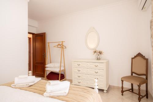 a bedroom with a bed with a dresser and a mirror at Altura Vacations V3, Algarve in Altura
