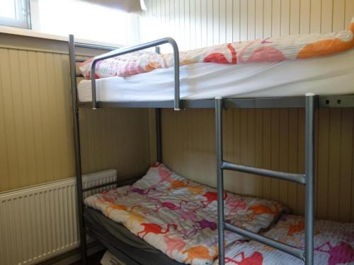 two bunk beds in a room with a window at Bungalow in Sint Maartenszee near beach in Sint Maartenszee