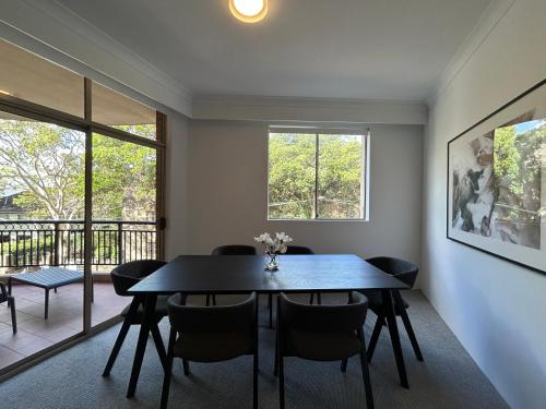 悉尼KozyGuru Camperdown Cozy 2-Bed Apt and Parking的有桌子和椅子的餐厅