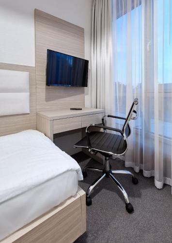 a bedroom with a bed and a desk and a chair at Hotel Maria in Dębno Polskie