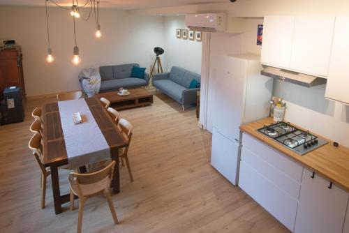 a kitchen and living room with a table and a couch at Moulin de Saza in Le Vigeant