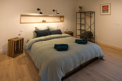 une chambre avec un grand lit avec deux oreillers dessus dans l'établissement Moulin de Saza, à Le Vigeant