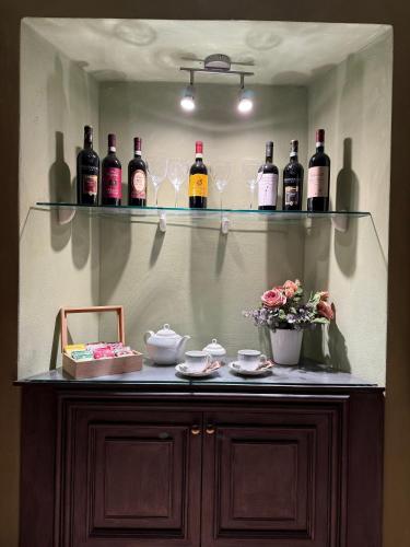 a shelf with wine bottles and glasses on it at Casa del Borgo in Bellano