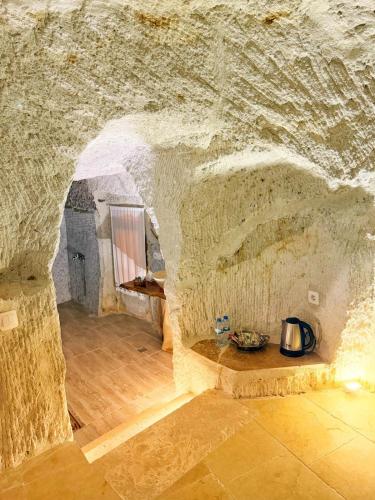 a room with a stone wall and a table in a cave at My Cave Suites in Nevsehir