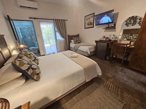 a bedroom with a bed and a desk and a television at Leopard Corner Lodge in St Lucia