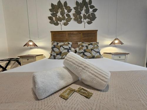 a white bed with two gold crosses on it at Leopard Corner Lodge in St Lucia