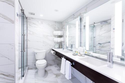 a white bathroom with a toilet and a sink at Weber's Hotel & Restaurant in Ann Arbor