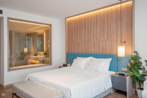 a bedroom with a large white bed and a mirror at Seaside Elegance- À la carte Hotel Hạ Long in Ha Long