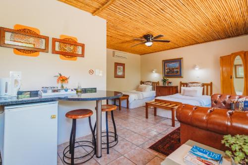 a living room with a couch and a bed at De Poort Country Lodge in Oudtshoorn