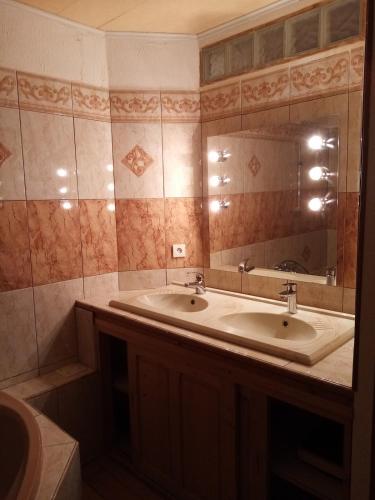 une salle de bain avec deux lavabos et un grand miroir dans l'établissement Superbe appart 6 personnes à Bois d 'Amont avec garage, à Bois-dʼAmont