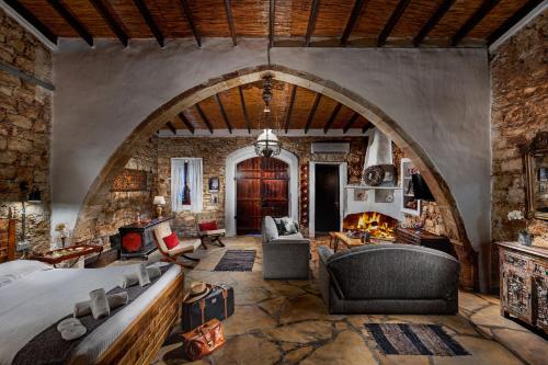 a large room with a bed and a stone wall at Oinoessa Traditional Boutique Guest Houses in Lofou