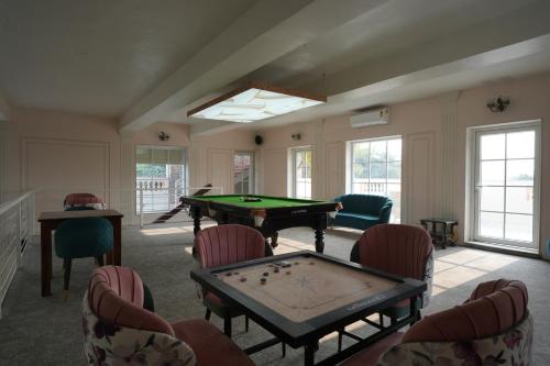 a room with a ping pong table and chairs at Astroport Sariska Treetop by Eight Continents in Tehla