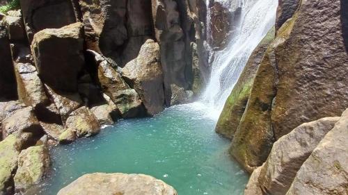 a waterfall in the middle of a rocky canyon at Cozy Vacation Retreat Apt 2 in Trafalgar