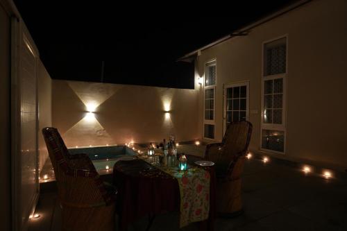 a room with a table and chairs at night at Astroport Sariska Treetop by Eight Continents in Tehla