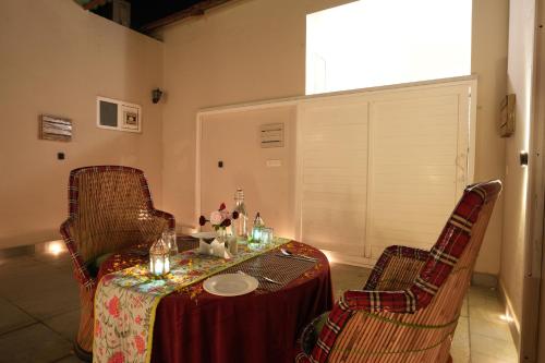 a table with two chairs and a table with a tableclotholitics at Astroport Sariska Treetop by Eight Continents in Tehla
