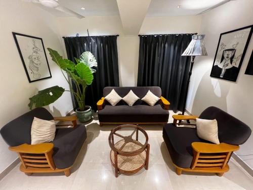 a living room with two chairs and a couch at Dhanvantari Luxury Hotel Near Kokilaben Dhirubhai Ambani Hospital Mumbai in Mumbai