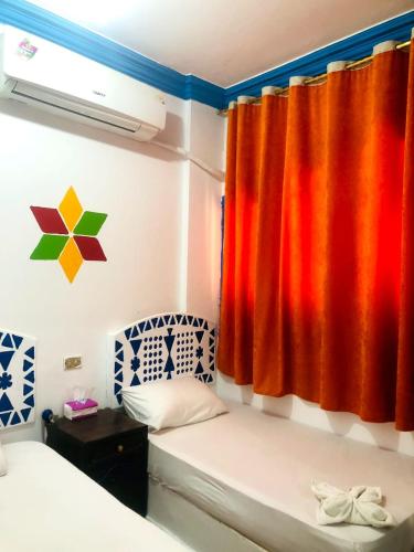 a room with a bed and a window with a curtain at Nubian Kulih house in Aswan