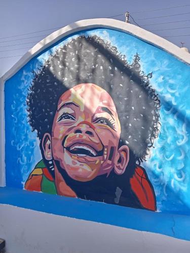 a painting of a boy on the side of a building at Nubian Kulih house in Aswan