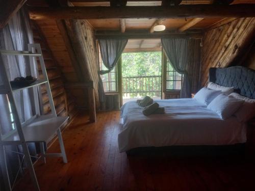 a bedroom with a bed with a teddy bear on it at Little Creek Cabins in Port Edward