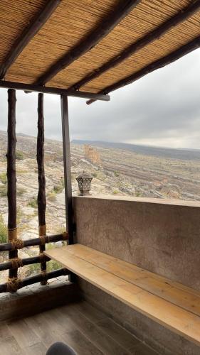 a view of the desert from a porch with a bench at Roghan Hospitality Inn in Al Ḩamrāʼ