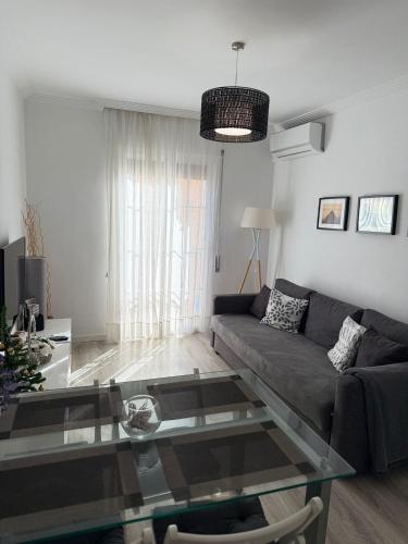a living room with a couch and a glass table at Apartamento Vega in Baena