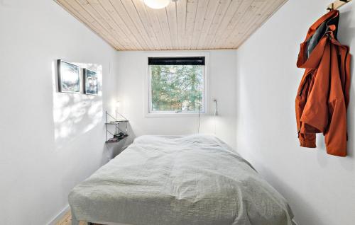 a bedroom with a bed in a white room at 4 Bedroom Awesome Home In Storvorde in Storvorde