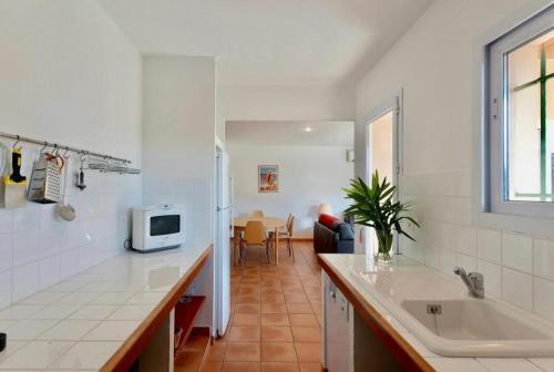 une cuisine blanche avec un évier et un micro-ondes dans l'établissement Villa Marina Rossa - plage à pied, à Lecci