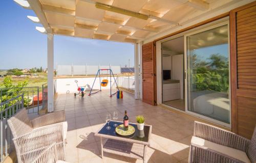a patio with a table and a playground on a balcony at Queen's Bay in Porto Palo